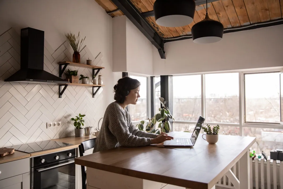 Woman comparing online GLP-1 programs on a laptop at a kitchen table
